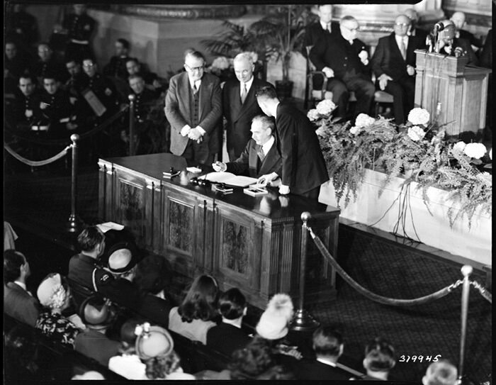 Secretary of State Dean Acheson signing the North Atlantic Treaty in 1949 as President Harry Truman and Vice President Alben Barkley look on