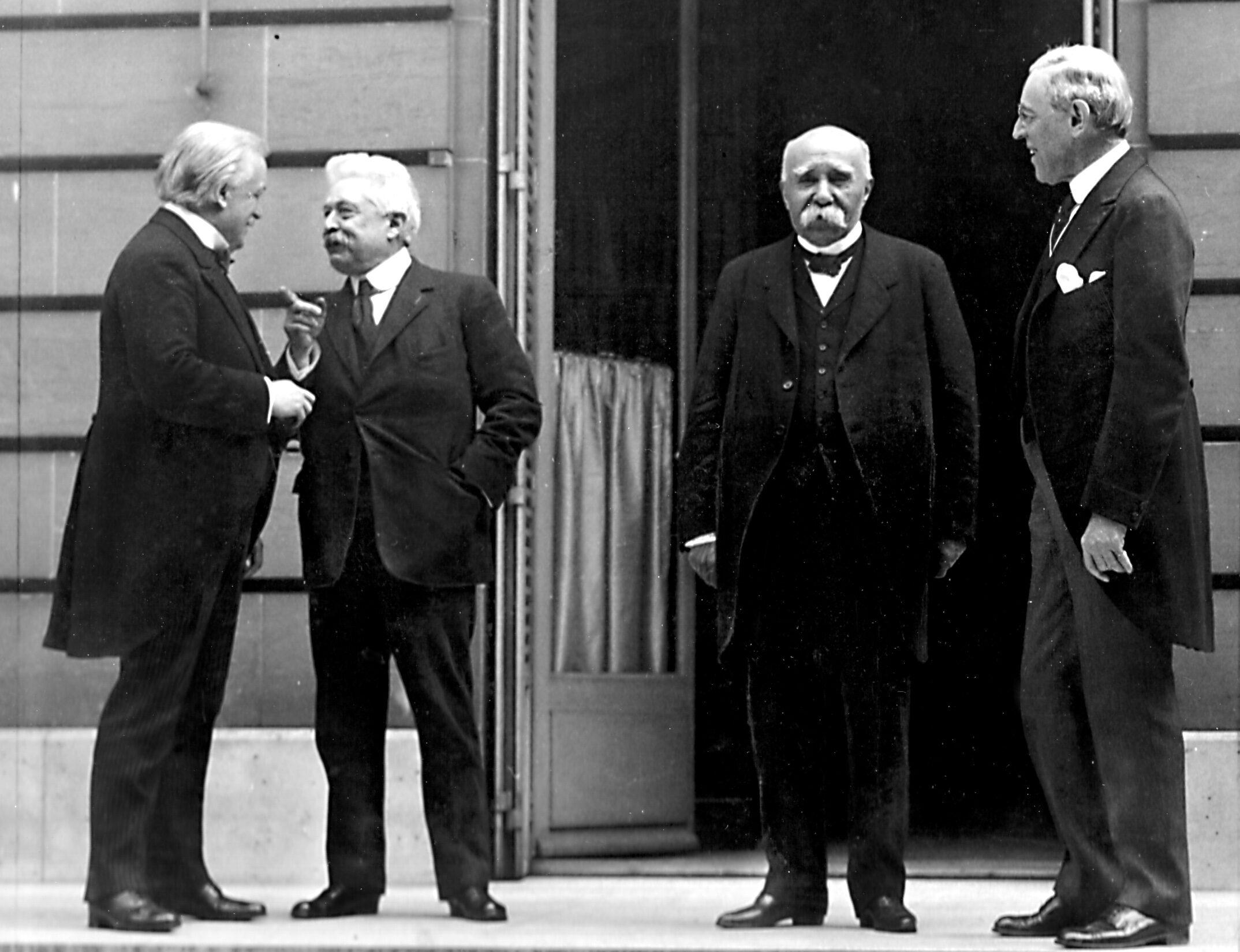 Woodrow Wilson standing with Allied leaders David Lloyd George, Vittorio Orlando, and Georges Clemenceau at the Paris Peace Conference in 1919